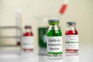 a vacina contra covid-19 em garrafas vermelhas e verdes foto