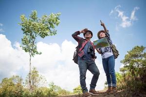 dois jovens viajantes com mochilas na selva verde foto