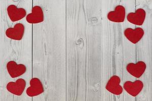 corações vermelhos nos cantos de um fundo de madeira branco e cinza. conceito de dia dos namorados foto