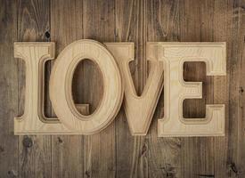 letras de madeira formando a palavra amor em um fundo de madeira de nogueira. conceito de st. Dia dos namorados foto