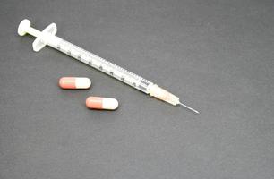 seringa com comprimido em preto foto