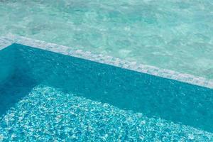 água de piscina bonita com sol relaxante brilha na superfície. férias de verão ou conceito de férias, textura de piscina foto