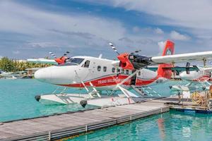 masculino, maldivas - 14.08.19 estacionamento de hidroavião próximo ao píer flutuante de madeira, maldivas. Transmaldivian Airways, maior empresa de hidroaviões do mundo foto