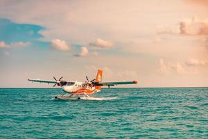 08.09.2019 - atol de ari, cena exótica das maldivas com hidroavião no desembarque no mar das maldivas. táxi de hidroavião no mar pôr do sol antes da decolagem. férias ou férias no fundo do conceito de maldivas. transporte aéreo foto