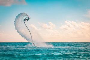 piloto profissional de fly board no mar tropical, fundo do conceito de esportes aquáticos. férias de verão diversão ao ar livre esporte e recreação foto