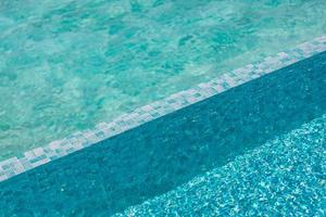 água de piscina bonita com sol relaxante brilha na superfície. férias de verão ou conceito de férias, textura de piscina foto