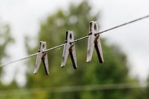 prendedores de roupa pendurados em uma corda. prendedores de roupa pendurados em um varal. fundo desfocado. foto