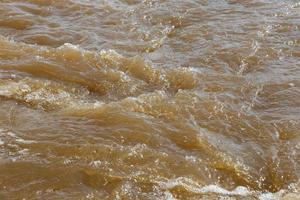 água barrenta do rio. rio de primavera com água barrenta marrom. fundo foto