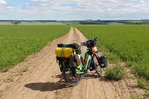 bicicleta do viajante em pé em uma estrada de campo. viagens de bicicleta. foto