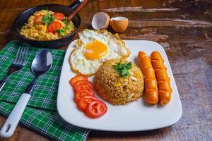 arroz frito servido com ovos e linguiça foto