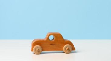 carro de brinquedo infantil de madeira vintage com rodas em fundo branco foto