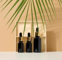 garrafa de vidro marrom com pipeta sobre fundo marrom claro, folha de palmeira. maquete de produto cosmético para cuidados com a pele