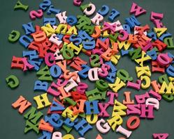 letras de madeira multicoloridas do alfabeto inglês sobre um fundo verde foto