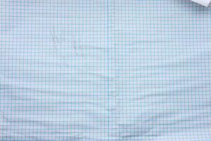textura de papel branco amassado em uma gaiola, linhas azuis, caderno escolar foto