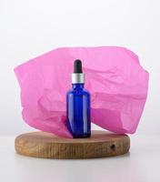 frasco de vidro azul com pipeta para cosméticos, óleos e soro. publicidade e promoção de produtos