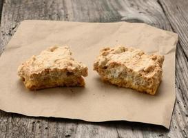 pedaços quadrados de biscoitos assados estão sobre um pedaço de papel, mesa cinza de madeira, biscoitos poloneses foto