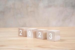 2023 feliz ano novo no bloco de madeira na mesa de madeira e fundo. conceito de ano novo. foto