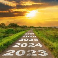 estrada de asfalto vazia e conceito de ano novo 2023. dirigindo em uma estrada vazia até 2023 com o pôr do sol. foto