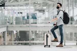 homem usando máscara e mochila no aeroporto