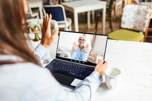 visão traseira da mulher fala em videochamada no computador com mãe idosa sorridente, jovem mulher se comunica online usando laptop webcam bate-papo com mãe madura feliz, quarentena em casa foto