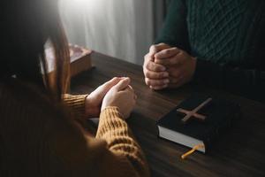 os cristãos são fiéis unem as mãos para orar e buscar as bênçãos de deus, a bíblia sagrada.estudo de deus foto