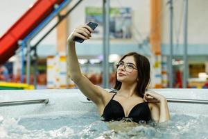 mulher tirando selfie na piscina foto