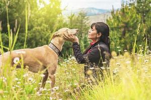 mulher sentada com seu galgo na natureza. foto