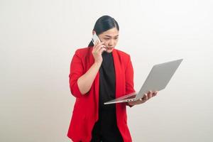 mulher de negócios asiáticos falando telefone com a mão segurando o labtop foto