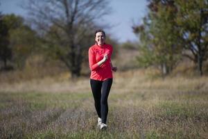 mulher sênior atlética alegre. mulher idosa positiva está fazendo uma corrida. retrato de uma idosa esportiva no parque foto