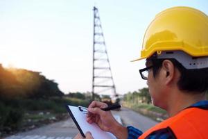 os engenheiros seguram a prancheta, verificam a lista de materiais na área de construção. conceito de empreiteiro de construção foto