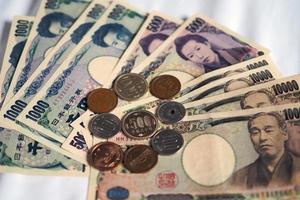 notas de ienes japoneses e moedas de ienes japoneses para o fundo do conceito de dinheiro foto