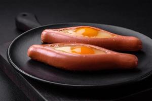 conceito composto de ovos fritos dentro de uma salsicha cortada com especiarias foto