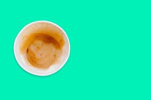 papel de xícara de café vazio após manchas de bebida e café isoladas em fundo verde. vista do topo. mínimo foto
