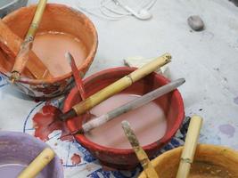 artesão marroquino pintando e decorando produtos cerâmicos na fábrica de cerâmica em fez, marrocos foto
