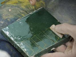 artesão marroquino pintando e decorando produtos cerâmicos na fábrica de cerâmica em fez, marrocos foto