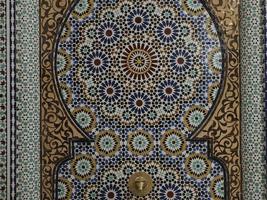 artesão de mosaico marroquino pintando e decorando produtos cerâmicos na fábrica de cerâmica em fez, marrocos foto