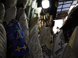 chinelos de couro feitos à mão coloridos esperando por clientes na loja em fes, ao lado de curtumes, marrocos foto