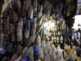 chinelos de couro feitos à mão coloridos esperando por clientes na loja em fes, ao lado de curtumes, marrocos foto