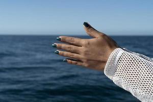 mulher negra com as mãos no fundo do mar unidas para rezar foto