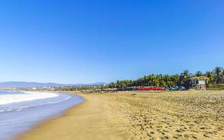 palmeiras sombrinhas espreguiçadeiras praia ondas puerto escondido mexico. foto