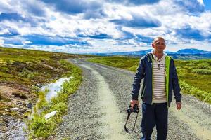jovem caminhante com câmera montanhas paisagem parque nacional de rondane noruega. foto