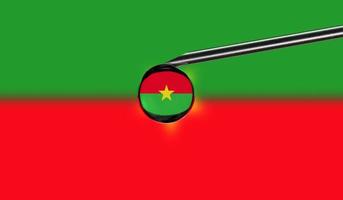 seringa de vacina com gota na agulha contra o fundo da bandeira nacional de burkina faso. vacinação de conceito médico. proteção contra pandemia de coronavírus sars-cov-2. idéia de segurança nacional. foto