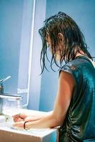 uma jovem lava as mãos na pia branca do vírus covid-19 foto