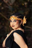 o rosto de uma mulher balinesa usando uma coroa de ouro e maquiagem no rosto com uma pele linda arrepiante foto