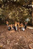 dança javanesa em trajes dourados enquanto usam uma pose de maquiagem juntos perto das folhas marrons foto