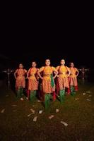 dançarinos balineses juntos com lenço vermelho e trajes laranja no palco depois de realizar a dança tradicional foto