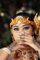 linda noiva indiana usando uma coroa de ouro e um colar de ouro com tatuagens nas mãos foto