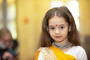 bielorrússia, cidade de gomil, 21 de maio de 2021. dia da amizade dos povos. linda garotinha indiana em sari olha para a câmera e sorri. foto
