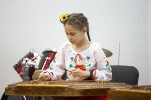 a menina toca o dulcimer instrumento étnico foto