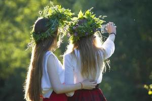 duas garotas em ivan kupala em camisas bordadas e grinaldas. foto